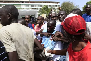 Injuries - An injured man is carried past the National Assembly building.&nbsp; (Photo: AP Photo/Rebecca Blackwell)
