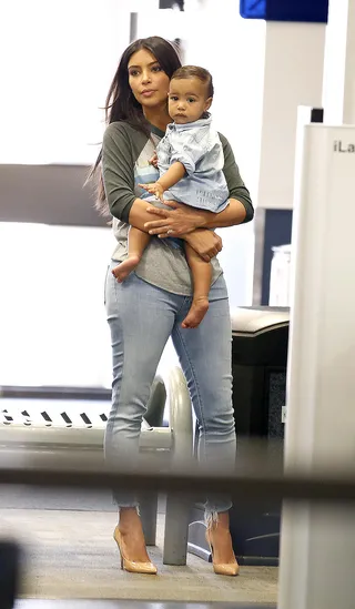 Jet-Setting Kiddie  - Kim K. totes her denim-clad princess through Burbank Airport. Baby Nori is just as stylish as mommy.  (Photo: Sharky/Splash News)