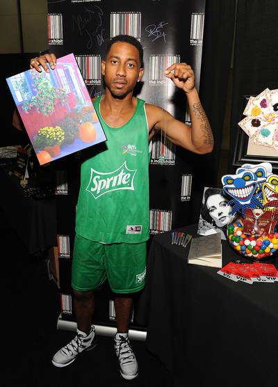 Arts and Crafts - Dressed in his BET Experience jersey, actor Brandon T. Jackson holds up a new painting and a heart-shaped charm necklace.&nbsp;(Photo: Angela Weiss/BET/Getty Images for BET)