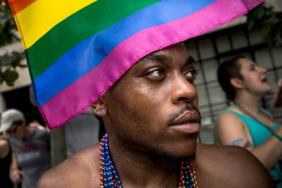 Rainbow Flags Fill Streets - Rainbow flags were popularized as a symbol for LGBT pride by San Francisco artist Gilbert Baker in 1978. Some attendees were creative in how they wore their flag, such as the man above, who donned the fabric as a hat. &nbsp;(Photo: Andrew Burton/Getty Images)