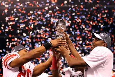 The Spoils of Victory - Wide receivers Victor Cruz (#80) and Hakeem Nicks raised the Vince Lombardi Trophy — emblematic of the NFL championship — after the Giants defeated the Patriots 21-17. (Photo: Ezra Shaw/Getty Images)