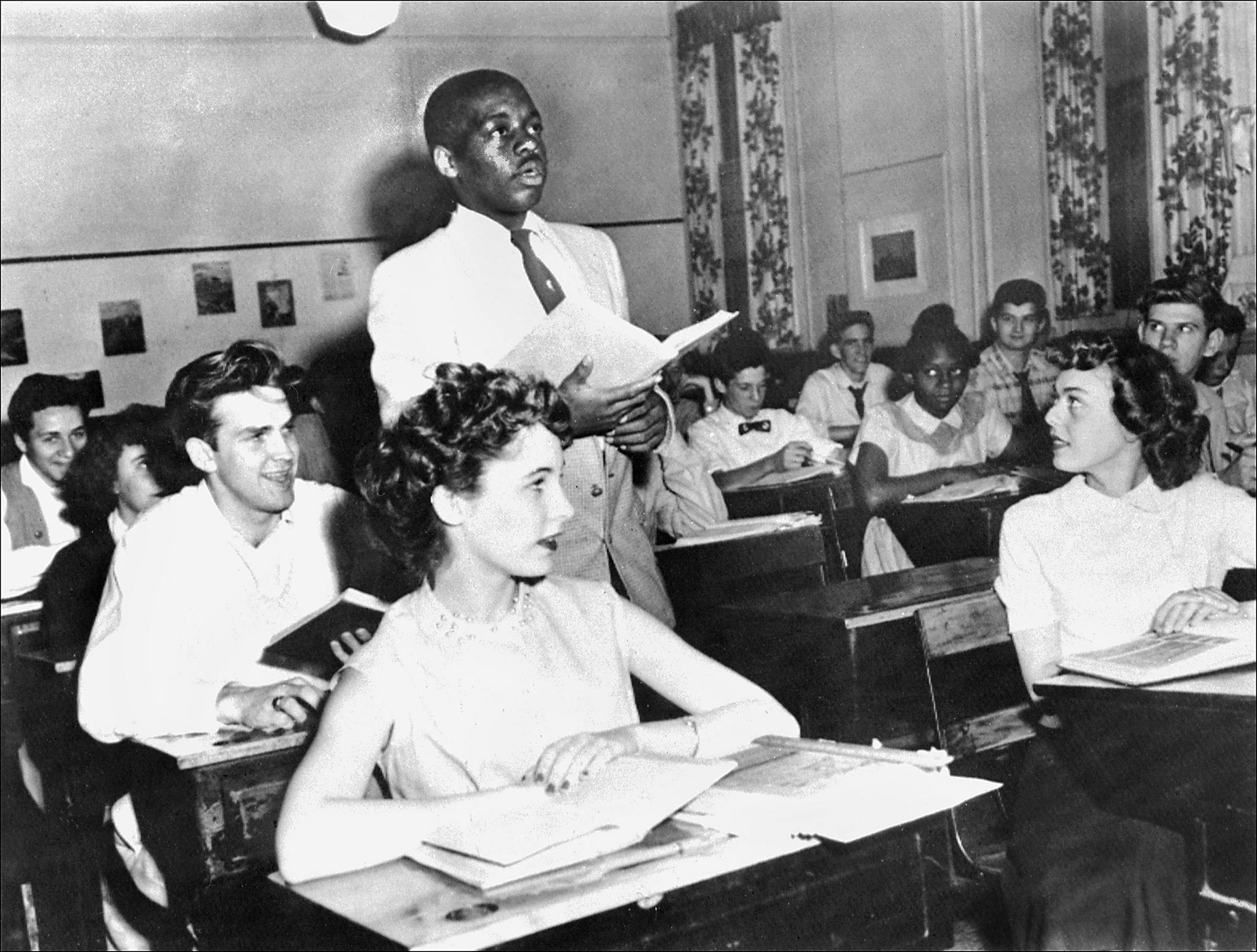 Brown v. Board of Education (1954) - The court ruled that &quot;separate schools are inherently unequal&quot; and banned segregation in public schools.&nbsp; The decision overturned Plessy v. Ferguson.In this image, a Black student recites his lesson surrounded by white fellows and others Black students on May 21, 1954, at Washington's Saint-Dominique school, where for the first time the Brown v. Board of Education decision was applied.&nbsp;(Photo: STAFF/AFP/Getty Images)
