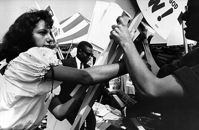Volunteers Lend a Hand - A young woman hands out picket signs.(Photo: National Archive/Newsmakers/Getty Images)