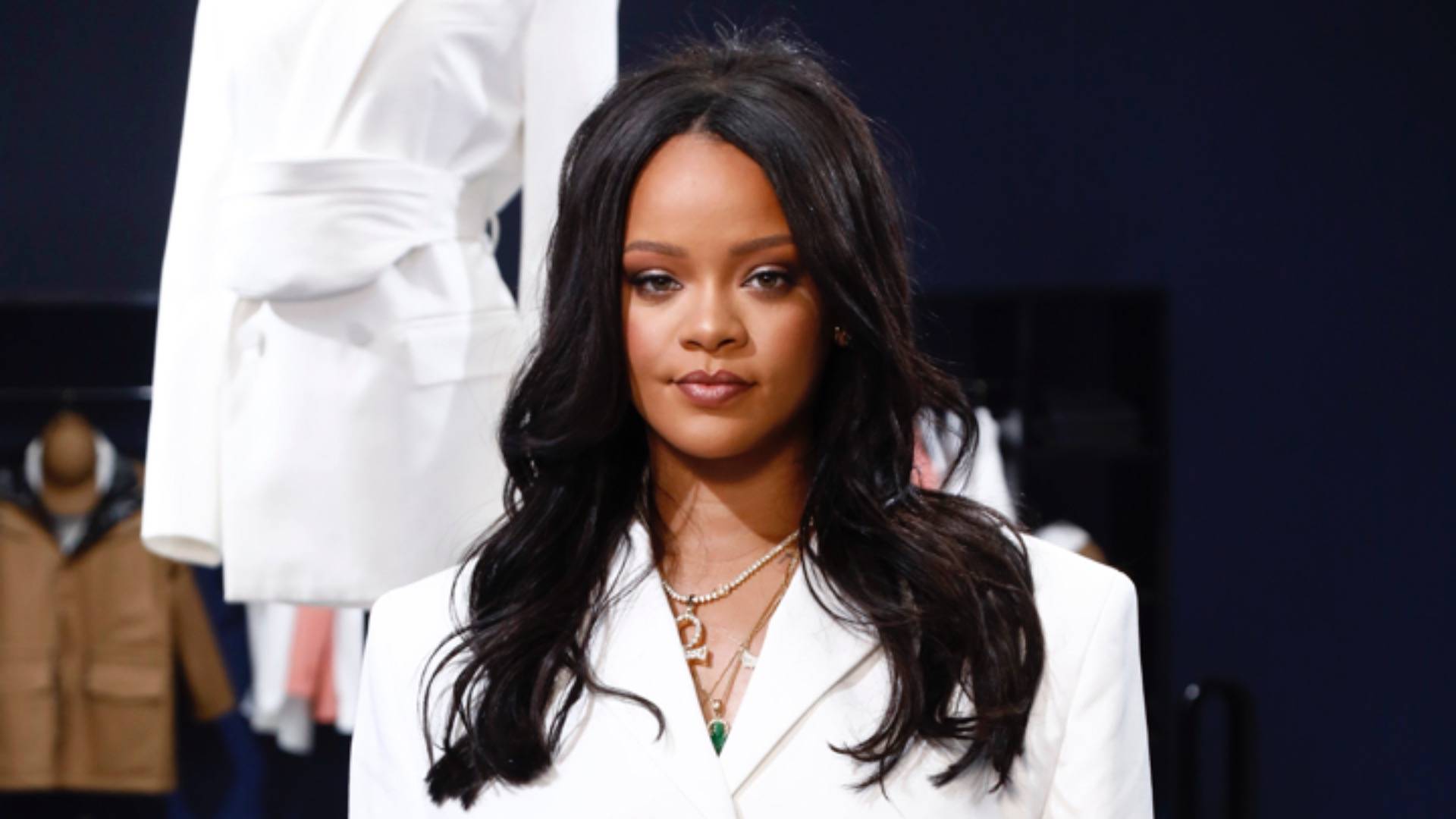 Rihanna posing with straight hair and white blazer 