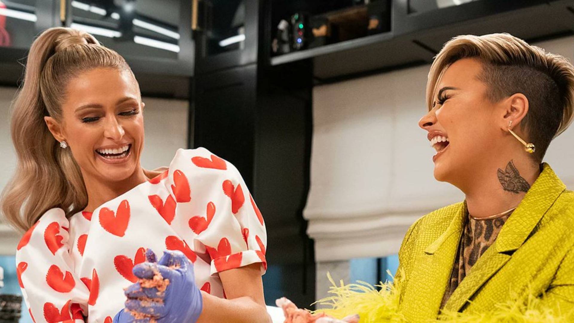 Paris Hilton and Demi Lovato laughing in the kitchen in a scene on 'Cooking With Paris' 