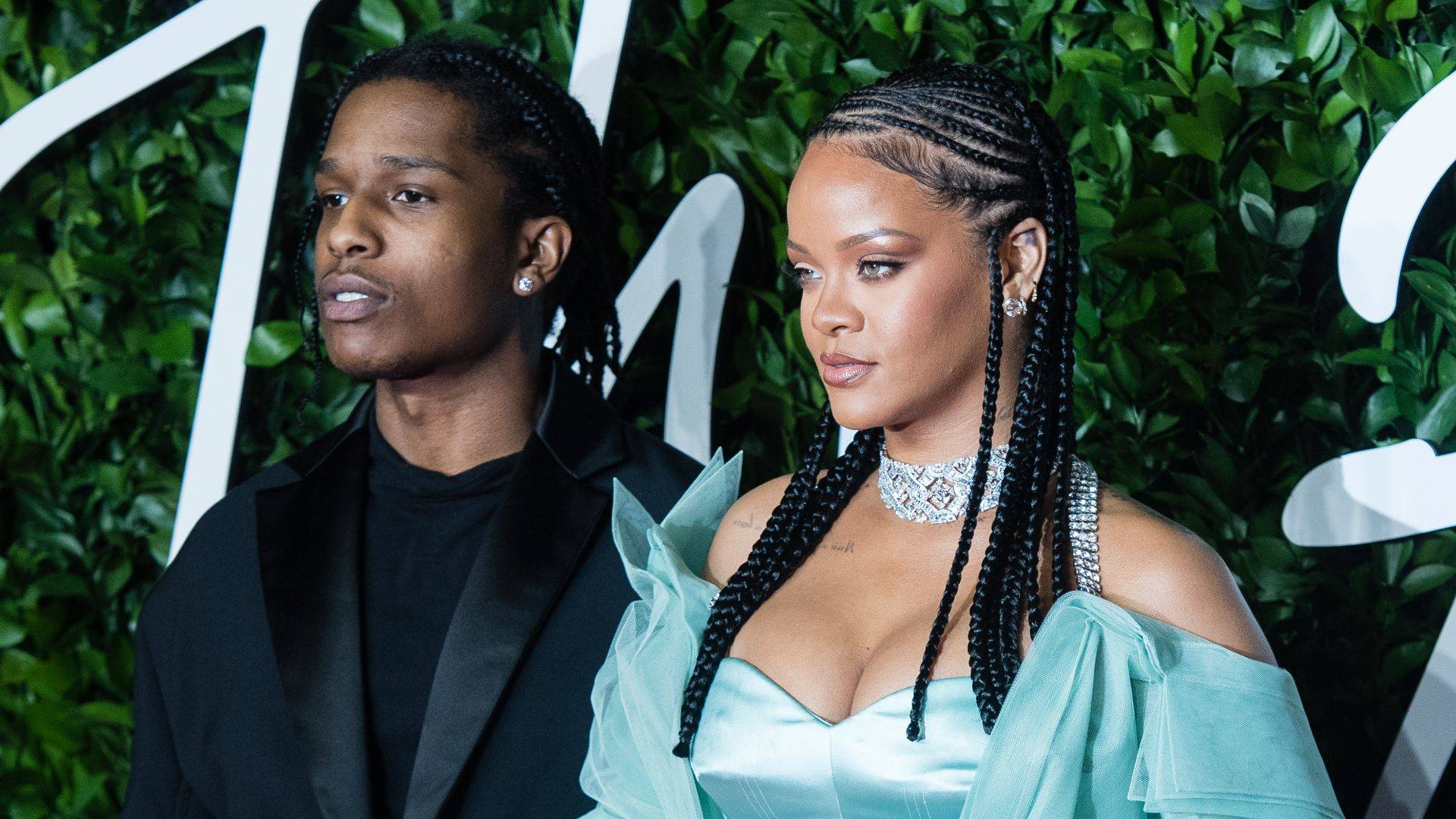 Rihanna in aqua dress standing alongside A$AP Rocky looking off camera