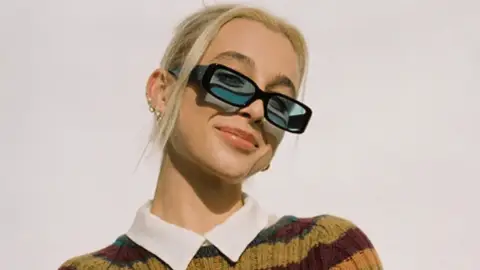 Emma Chamberlain YouTuber smiling with glasses on light hair cool instagram image white top jumper