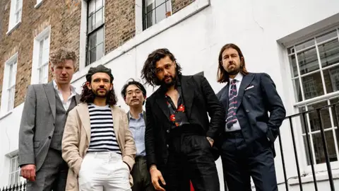 Five members of Australian band Gang Of Youths posing in front of building in Angel, London