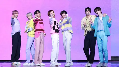 K-pop group Enhypen posing on stage in front of pink background