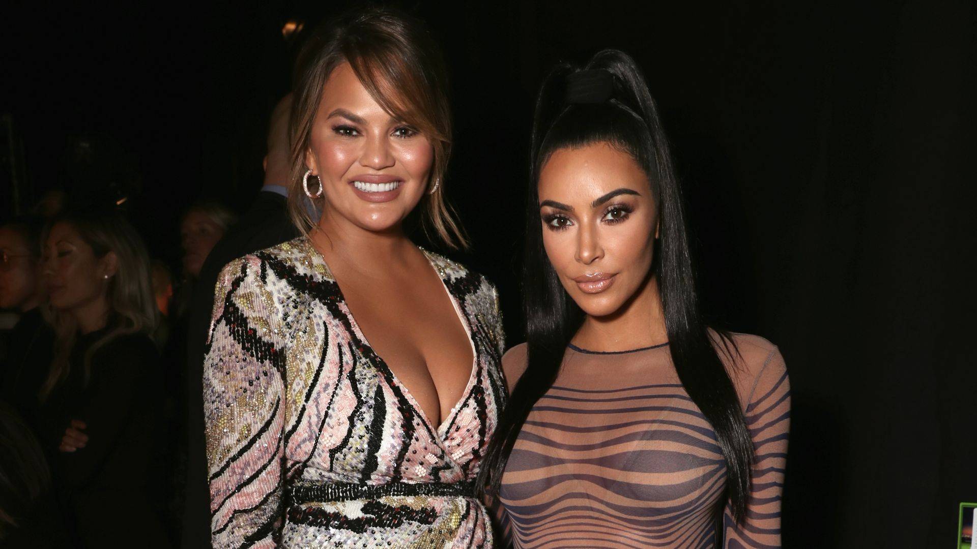 Kim Kardashian and Chrissy Teigen smile at camera for event 2018