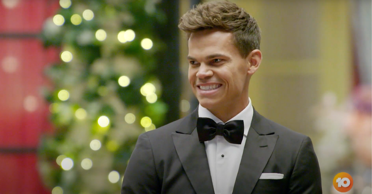 Jimmy Nicholson From The Bachelor Australia, smiling and looking off camera in a tuxedo 