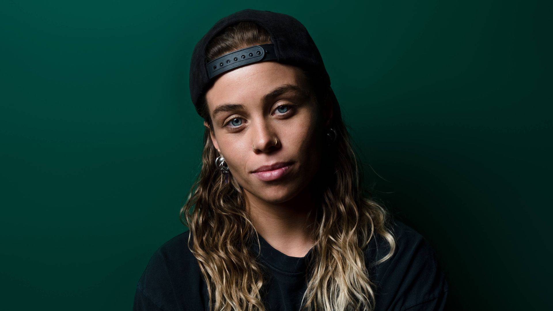 Tash Sultana pauses for picture green wall MTV
