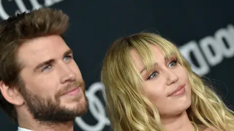 Close up of Miley Cyrus and Liam Hemsworth posing and looking off camera at Avengers: Endgame premiere