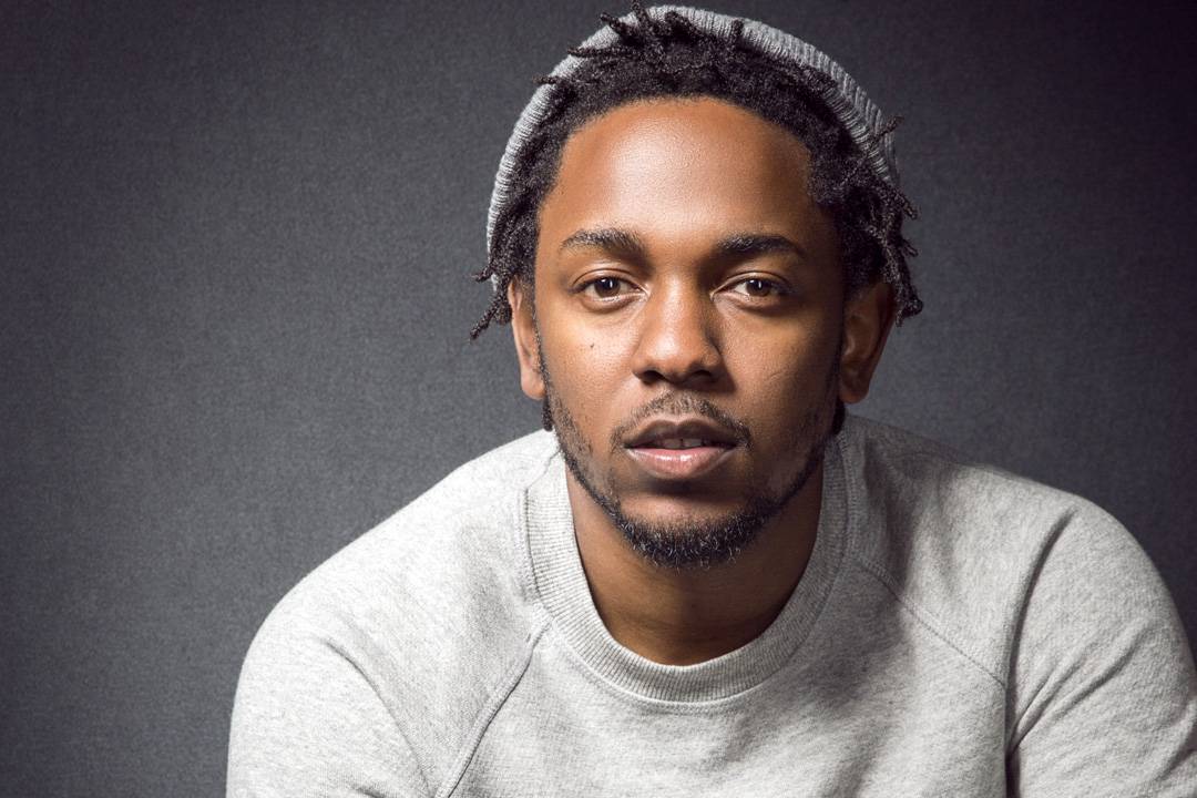 Kendrick Lamar poses for MTV against a gray backdrop.