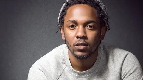 Kendrick Lamar poses for MTV against a gray backdrop.