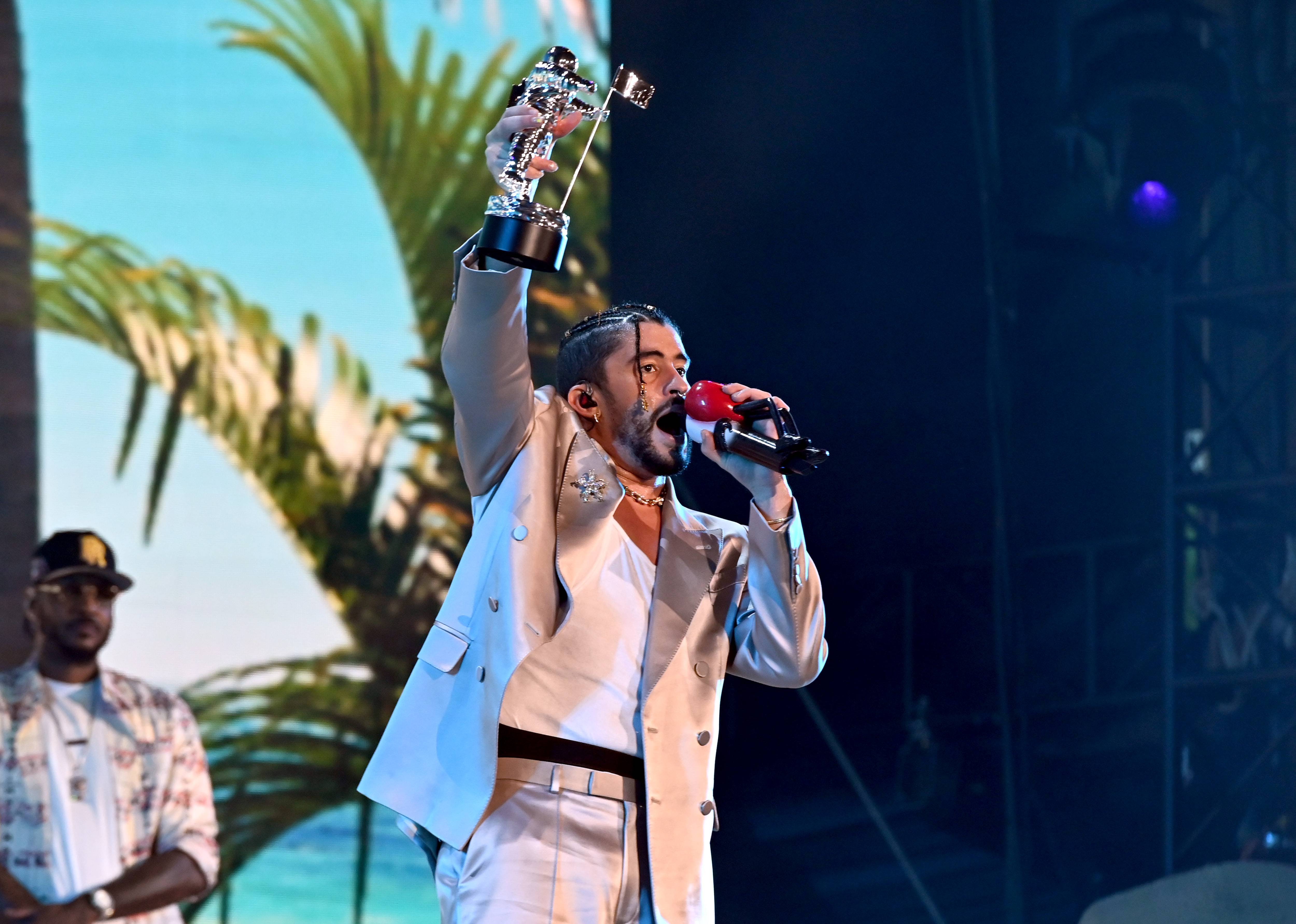Bad Bunny holds up his Moon Person trophy for Artist of the Year at the 2022 MTV VMAs.
