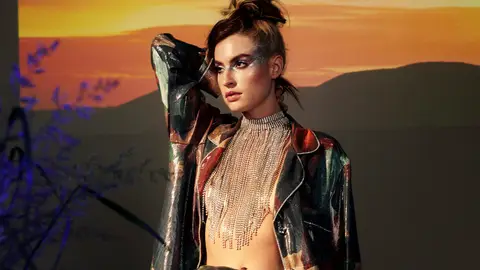 Alt-pop singer Fletcher poses in full glam in front of a desertscape.