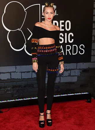 Miley Cyrus brings a playful twist to the 2013 VMA red carpet in a bejeweled black crop top with matching leggings.