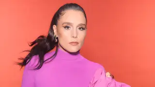 Jessie Ware poses in purple against a peach background