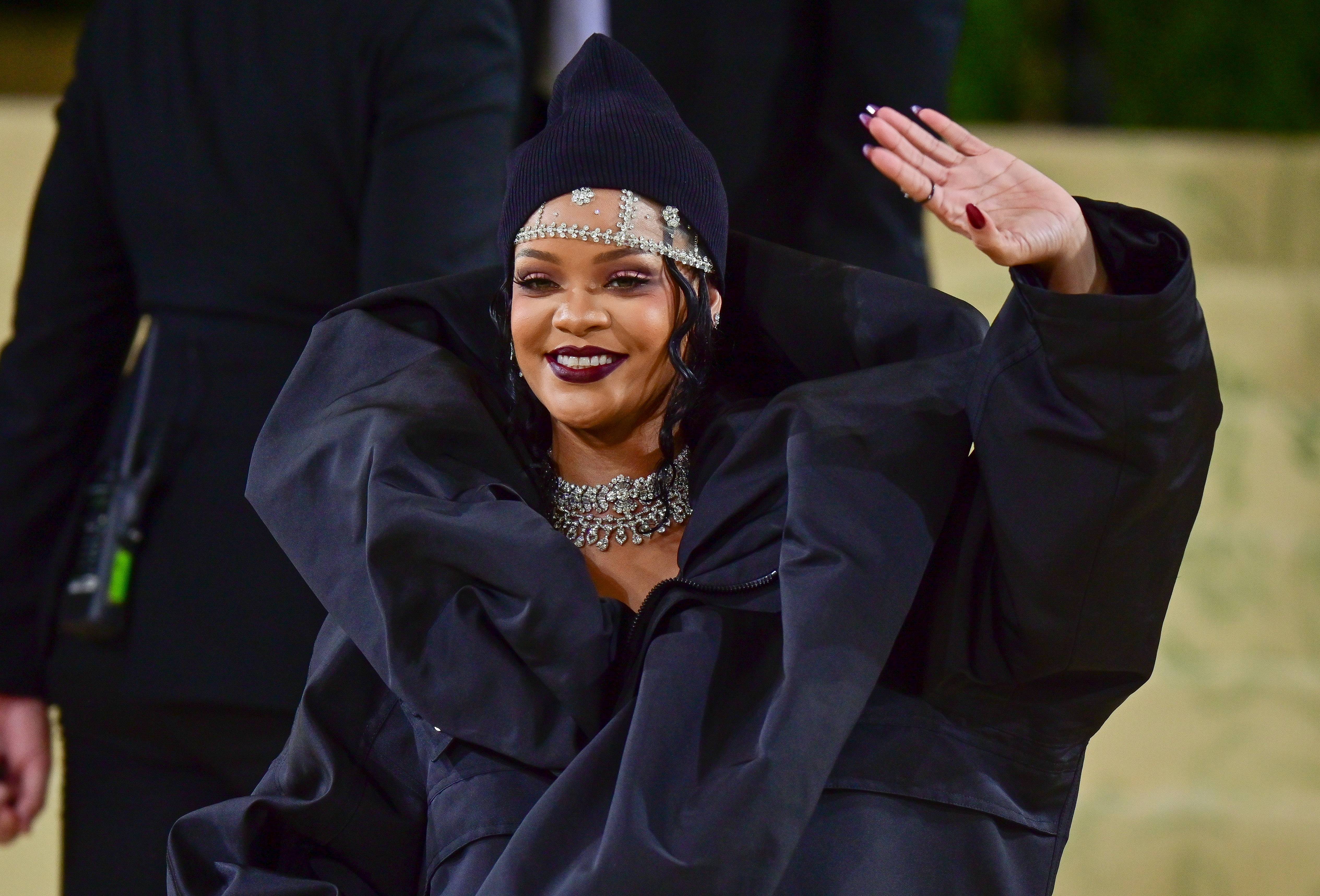 Rihanna appears on the red carpet for the 2022 Met Gala decked out in all black and waves to her adorers.