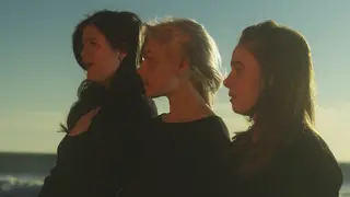 Boygenius (the musical trio of Lucy Dacus, Phoebe Bridgers, and Julien Baker) pose on the beach in profile