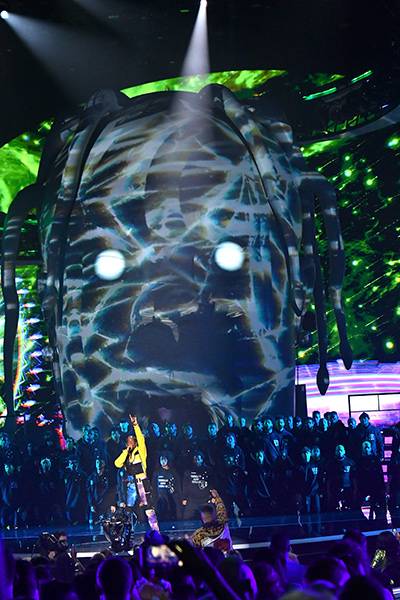 Appearing on stage via an roller coaster ride car, Travis Scott performed “Stargazing,” Stop Trying To Be God,” and “Sicko Mode” from his latest album Astroworld, in front of is iconic inflatable head at the 2018 VMAs.