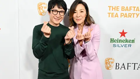 Ke Huy Quan and Michelle Yeoh make finger hearts at the BAFTA Tea Party in January 2023