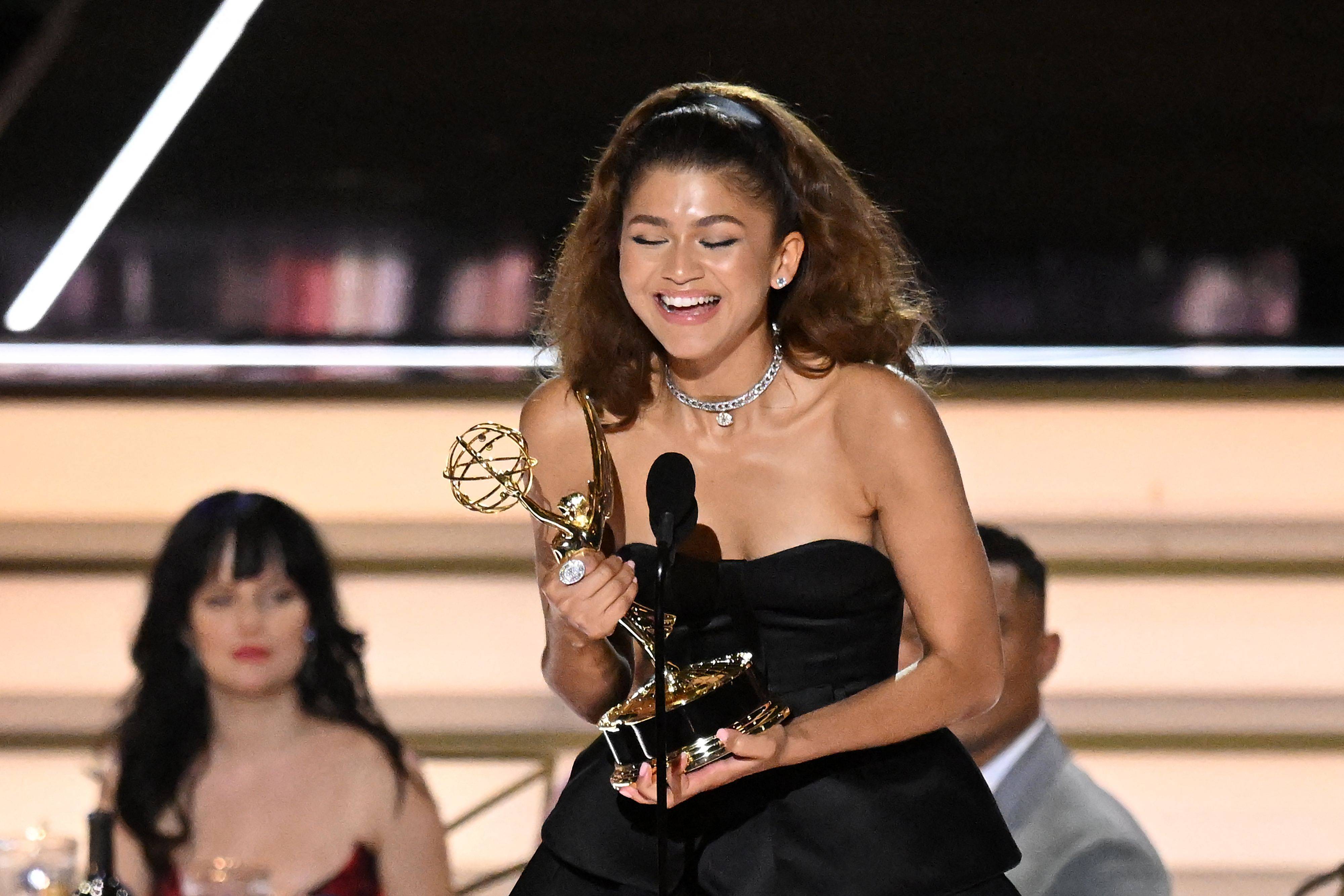 Zendaya accepts her trophy for Outstanding Lead Actress in a Drama Series for her work on 'Euphoria' onstage in a black dress at the 2022 Emmys.