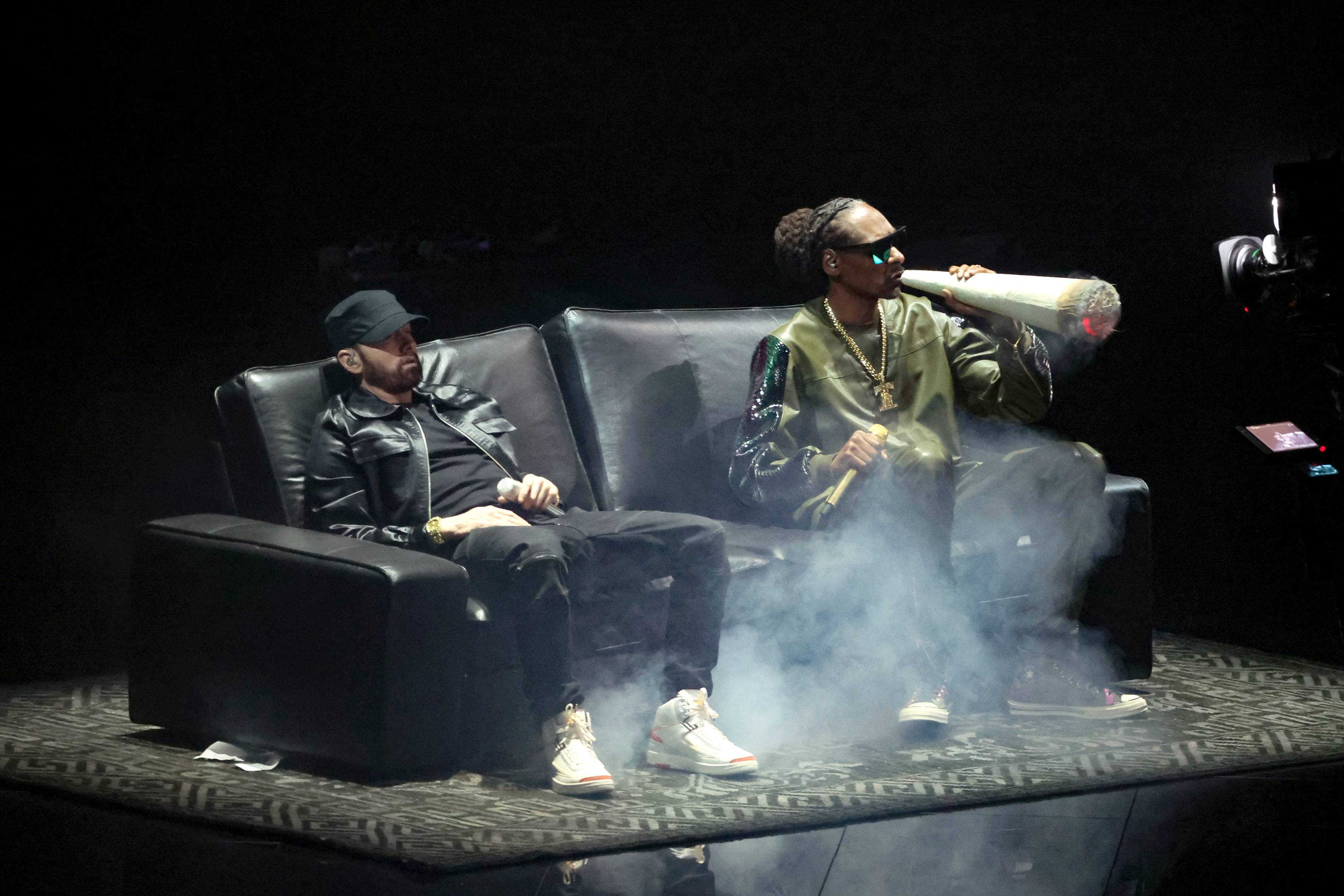 Eminem and Snoop Dogg smoke a giant blunt on a black couch during their 2022 MTV VMAs performance.