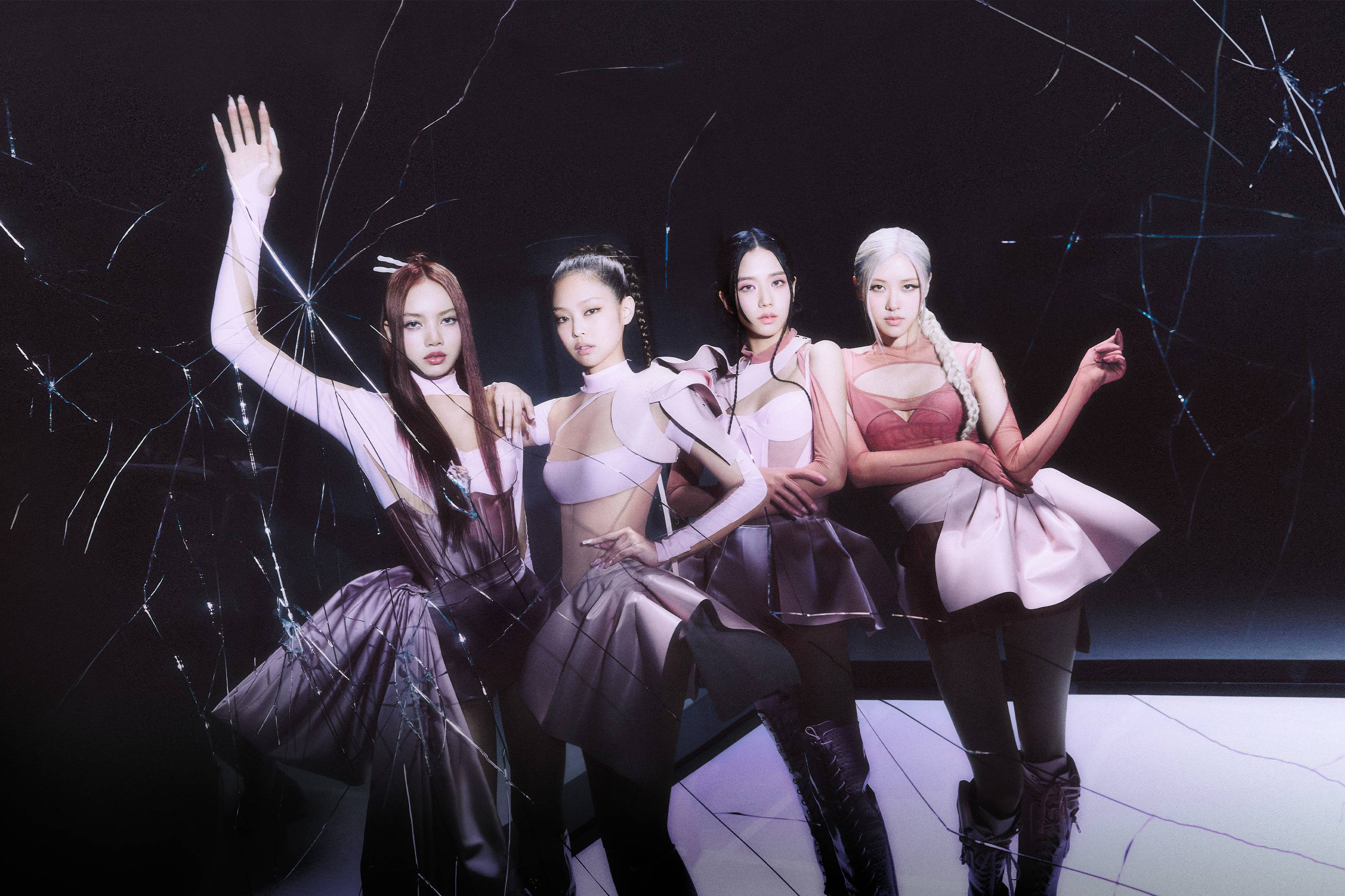 K-pop girl group Blackpink pose in a darkened room.