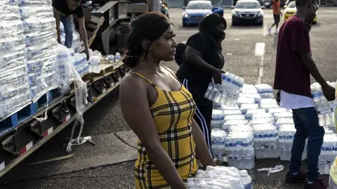 Aelicia Hodge helps hand out cases of bottled water at a Mississippi Rapid Response Coalition distribution site on August 31, 2022 in Jackson, Mississippi. 
