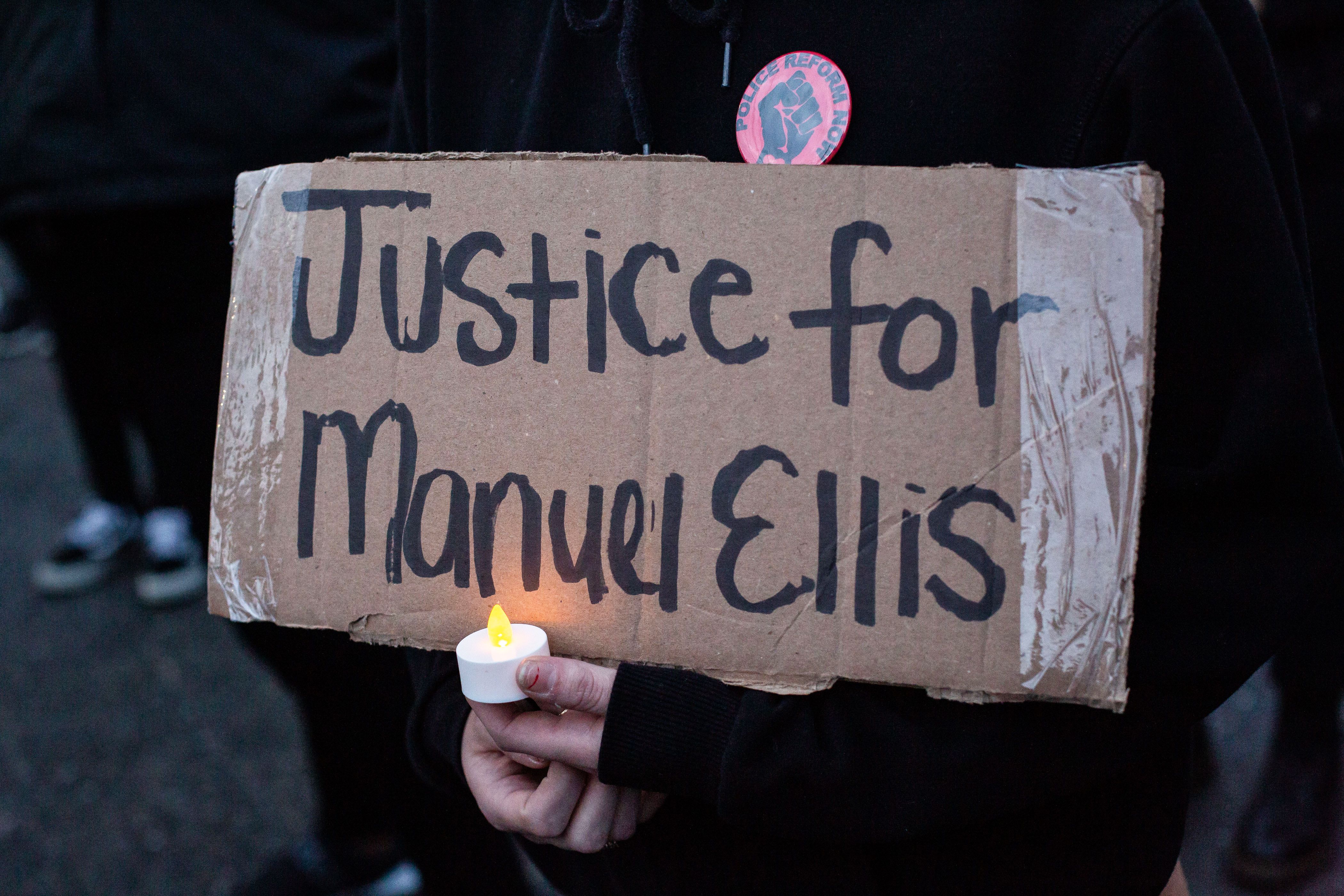 TACOMA, WA - JUNE 03: A person holds a sign during a vigil for Manuel Ellis, a black man whose March death while in Tacoma Police custody was recently found to be a homicide, according to the Pierce County Medical Examiners Office, near the site of his death on June 3, 2020 in Tacoma, Washington. Protests and other events sparked by the death of George Floyd have continued in the Tacoma area after the Medical Examiner found that the cause of death in the Manuel Ellis case was caused by respiratory arrest due to hypoxia due to physical restraint. (Photo by David Ryder/Getty Images)