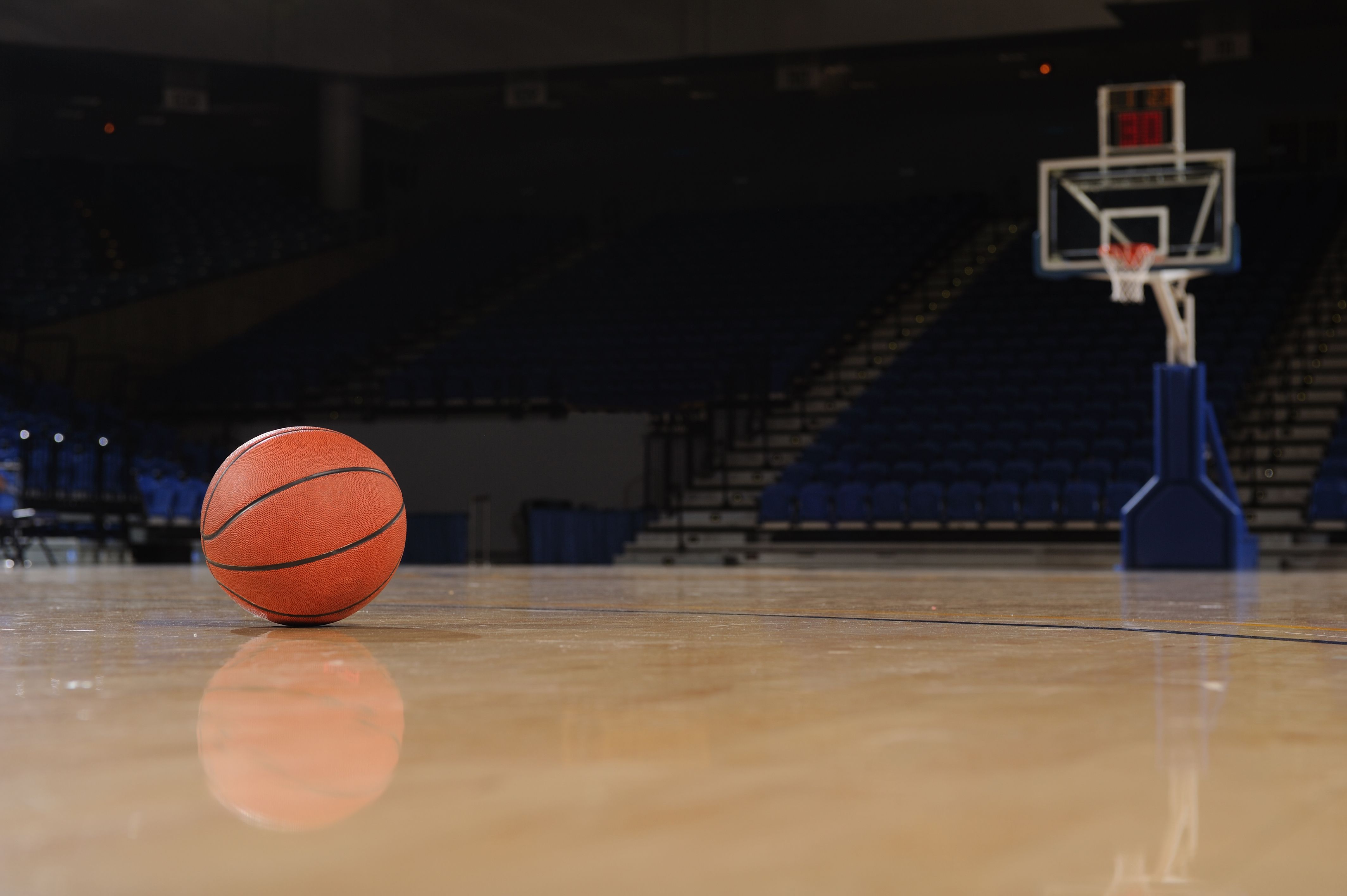 Basketball on the floor of a indoor court.