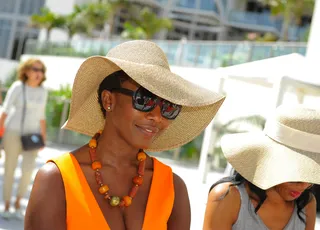 Cool and Collected - Dr. Ingleton soaks up the hair session in her own wide-brimmed hat and squared dark frames.  (Photo: Sergi Alexander/Getty Images)