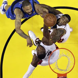 Battling for the Ball - Dallas Mavericks' Tyson Chandler battles for a rebound with Miami Heat's Dwyane Wade (3) and Udonis Haslem. (Photo: AP Photo/David J. Phillip; Pool)