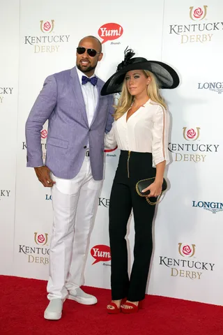 Purple Reign - Reality TV couple Hank Baskett and Kendra Wilkinson Baskett pose for photographers before heading to their seats. (Photo: Joey Foley/FilmMagic)