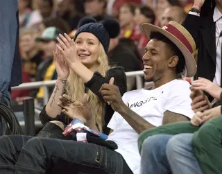 Game Time - The couple shares a laugh at a UCLA men’s basketball game in January. Their hats make their looks stand out: She wears a black knit cap with twin pom-poms&nbsp;with a gray sweater and black jeans. His straw-colored topper is paired with a white T and textured jeans.&nbsp; (Photo: BRM/Star Max/GC Images)