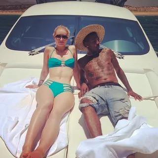 On a Boat - The couple dresses all the way down for a relaxing boat ride. She wears an itty-bitty bikini with hip cutouts and a halter-style top. He rocks jean shorts and a straw hat.&nbsp; (Photo: Iggy Azalea via Instagram)