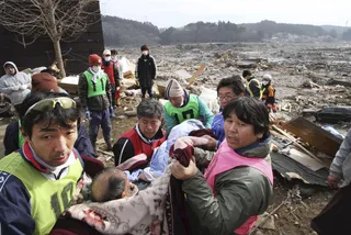 Rescued - Workers carry an elderly man found alive by tsunami survivors buried under rubble along a slope of a hill in Minamisanriku in Miyagi Prefecture (state) on Monday.  (Photos: AP Photo/The Yomiuri Shimbun, Hiroaki Ohno)