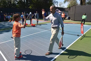 Let's Play - Obama greets his doubles partner.  (Photo: MANDEL NGAN/AFP/Getty Images)