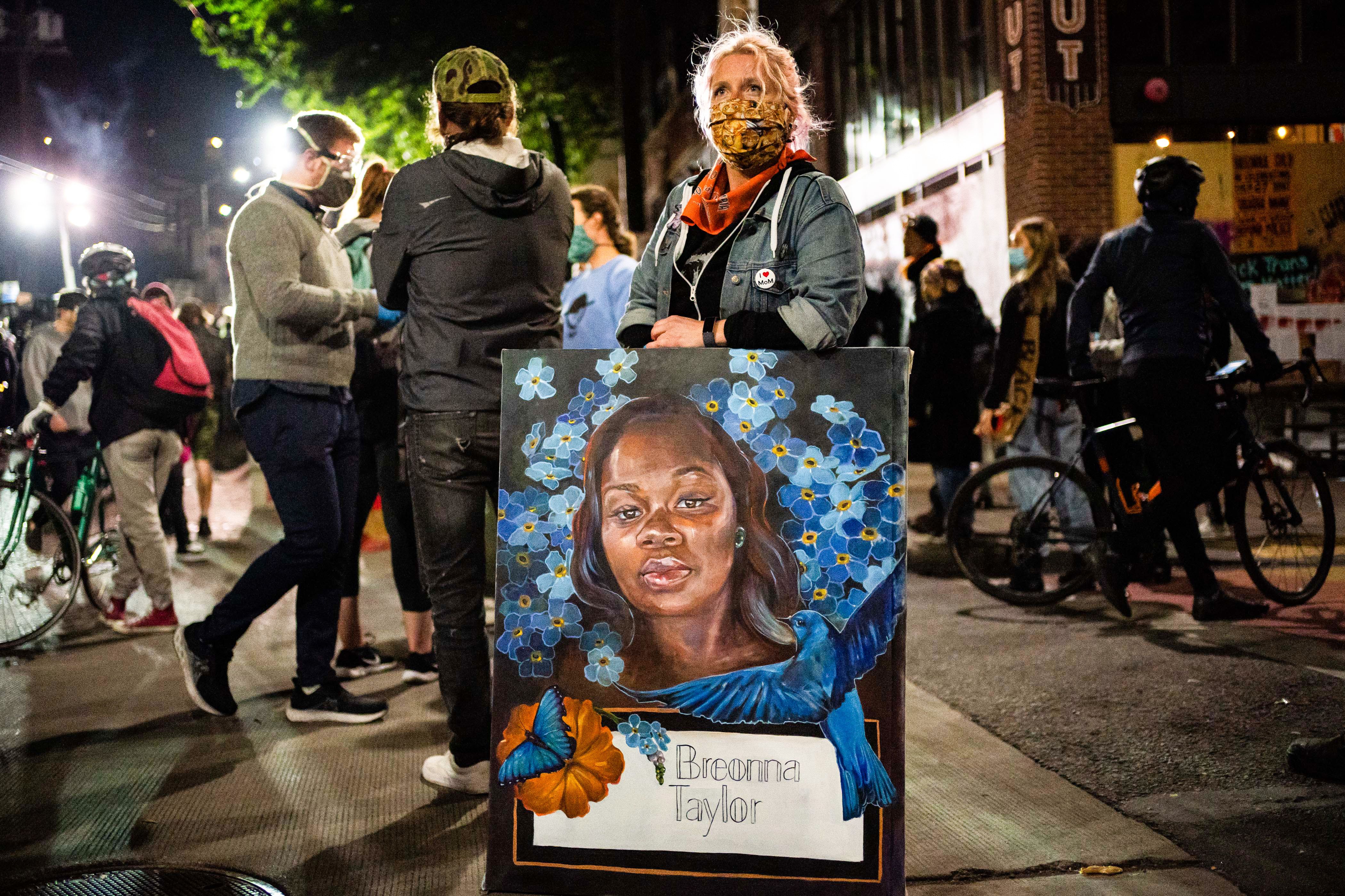 SEATTLE, WA - JUNE 07: A demonstrator holds a painting of Breonna Taylor during a protest near the Seattle Police Departments East Precinct on June 7, 2020 in Seattle, Washington. Earlier in the evening, a suspect drove into the crowd of protesters and shot one person, which happened after a day of peaceful protests across the city. (Photo by David Ryder/Getty Images)