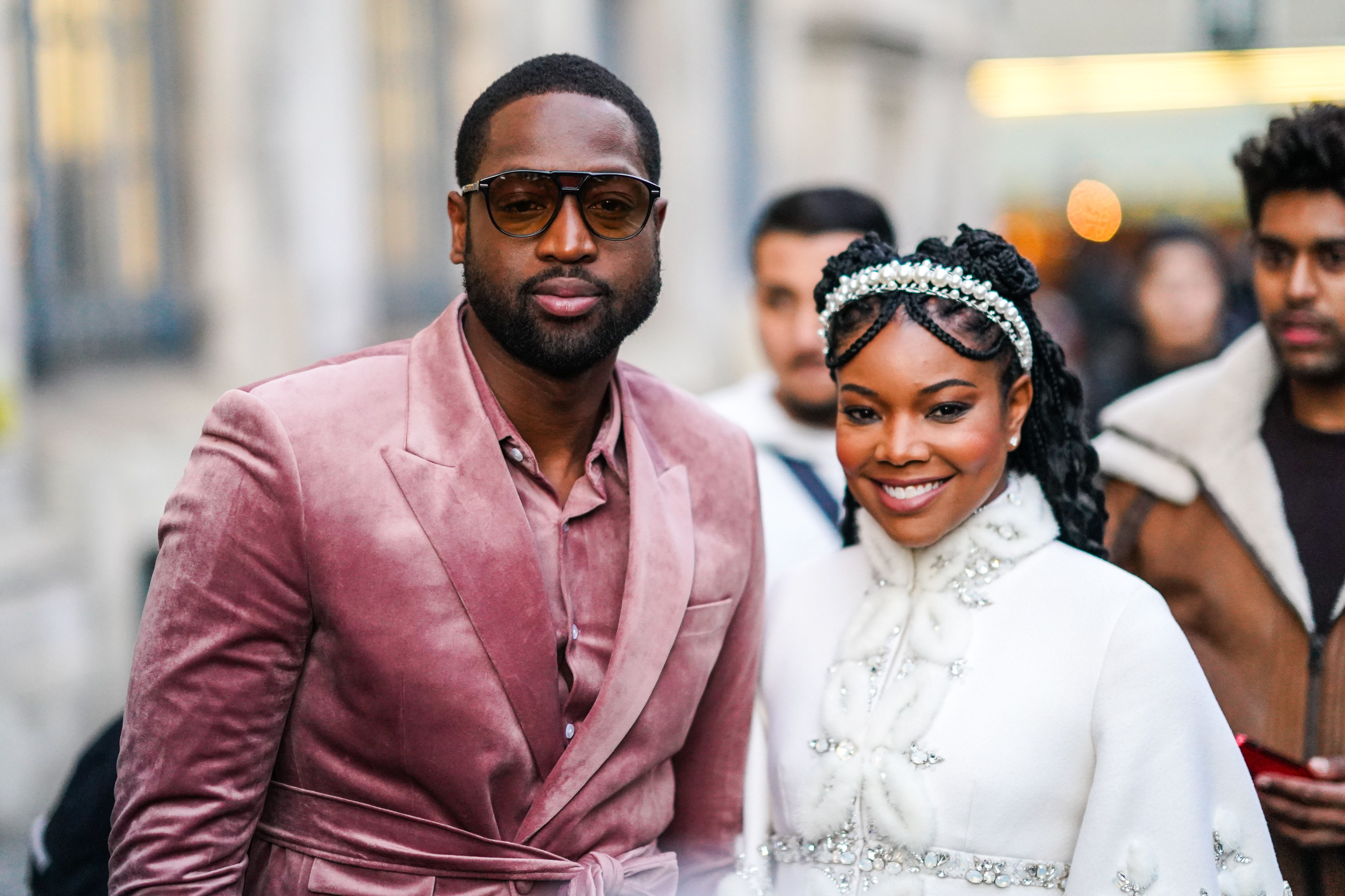 PARIS, FRANCE - JANUARY 20: Dwayne Wade (L) wears sunglasses, a pink velvet shirt, a pink velvet jacket, a matched belt  ;  Gabrielle Union (R) wears a pearl headband, a white fluffy jacket with rhinestone embroideries, a mandarin collar and bell sleeves, outside Ralph & Russo, during Paris Fashion Week - Haute Couture Spring/Summer 2020, on January 20, 2020 in Paris, France. (Photo by Edward Berthelot/Getty Images )