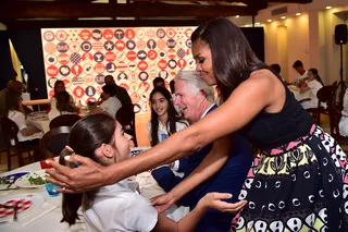 Warm Welcome - The first lady also made time for hugs with the students before heading on to her next destination. Too sweet!(Photo: GIUSEPPE CACACE/AFP/Getty Images)