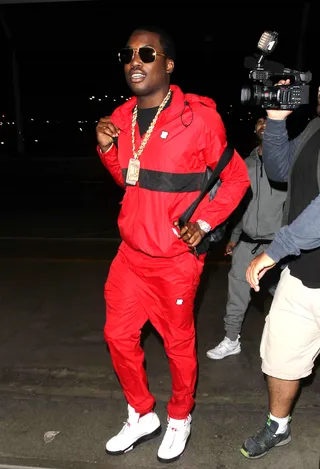 Red All Over - Meek Mill isn't hard to spot at LAX airport in his bold warm up suit. The rapper is seen on his way to catch a flight to the Big Apple.(Photo: Sonia Hall / Splash News)