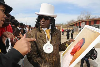 Remembering the Fallen - Flavor Flav listened as a fan explained the significance of a piece of art presumed to be of a fallen young man.(Photo: Johnny Nunez/BET)