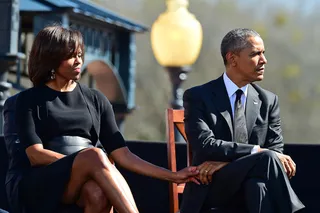 Unwavering Support - The first lady holds the president's hand before he is introduced to speak to thousands outside of the Edmund Pettus Bridge in Selma.&nbsp;(Photo: AP Photo/Bill Frakes)