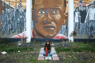 Mourning Continues - Woman sits near a mural of Freddie Gray near the corner where his deadly arrest occurred.&nbsp;   (Photo: Patrick Semansky/ AP PHOTO)