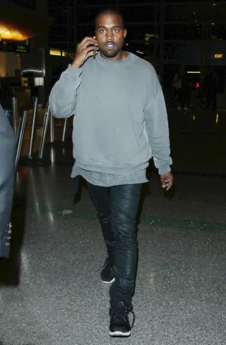 Man on the Move - Kanye West&nbsp;definitely knows how to multi-task as he chats on the phone while walking through LAX airport before boarding a flight.(Photo: Splash News)