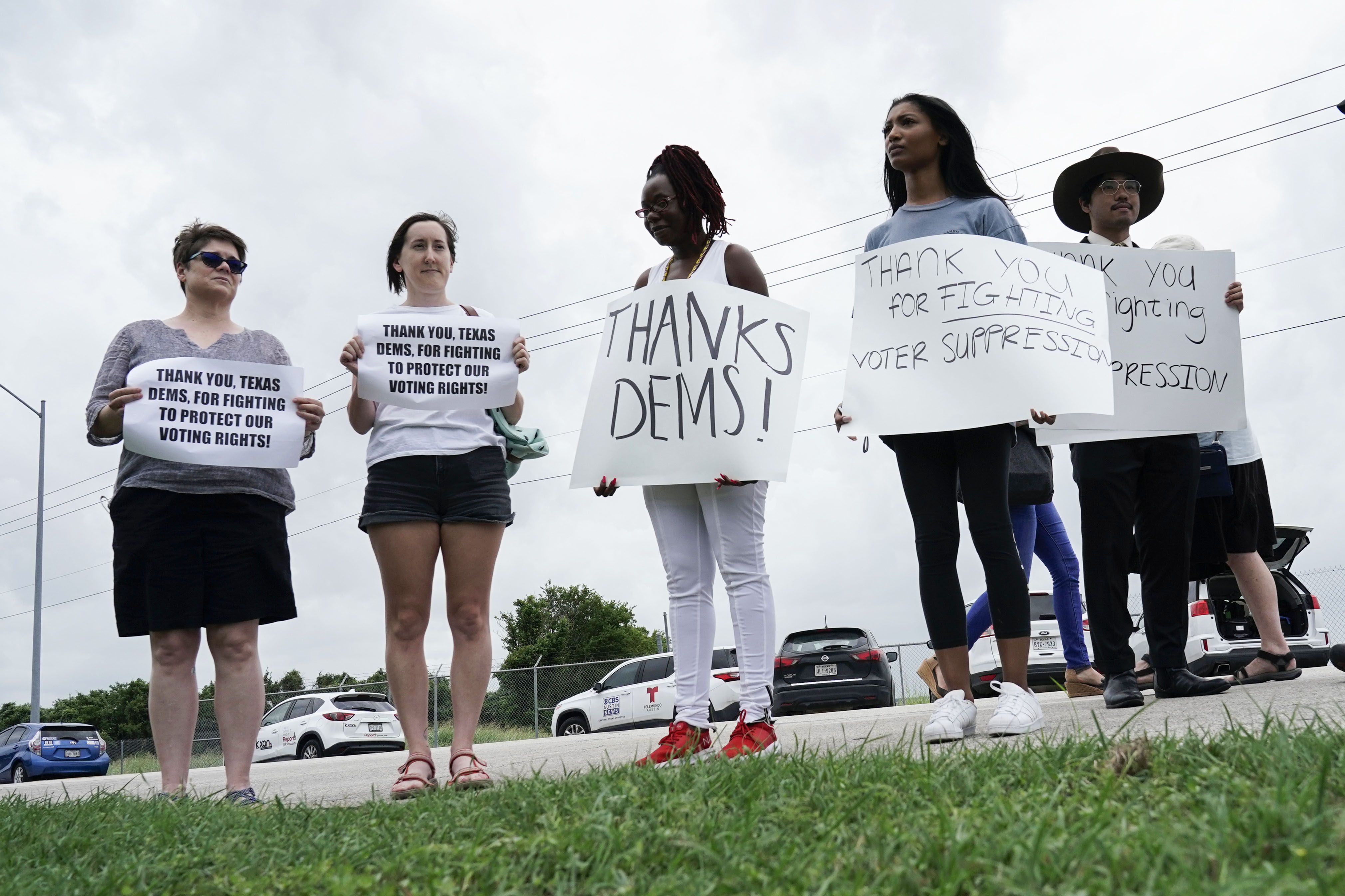 Supporters gather on the street as Democrats from the Texas Legislature arrive by bus to board a private plane headed for Washington, D.C., Monday, July 12, 2021, in Austin, Texas. By leaving, Democrats again deny the GOP majority a quorum to pass bills, barely a month after their walkout thwarted the first push for sweeping new voting restrictions in Texas. (AP Photo/Eric Gay)