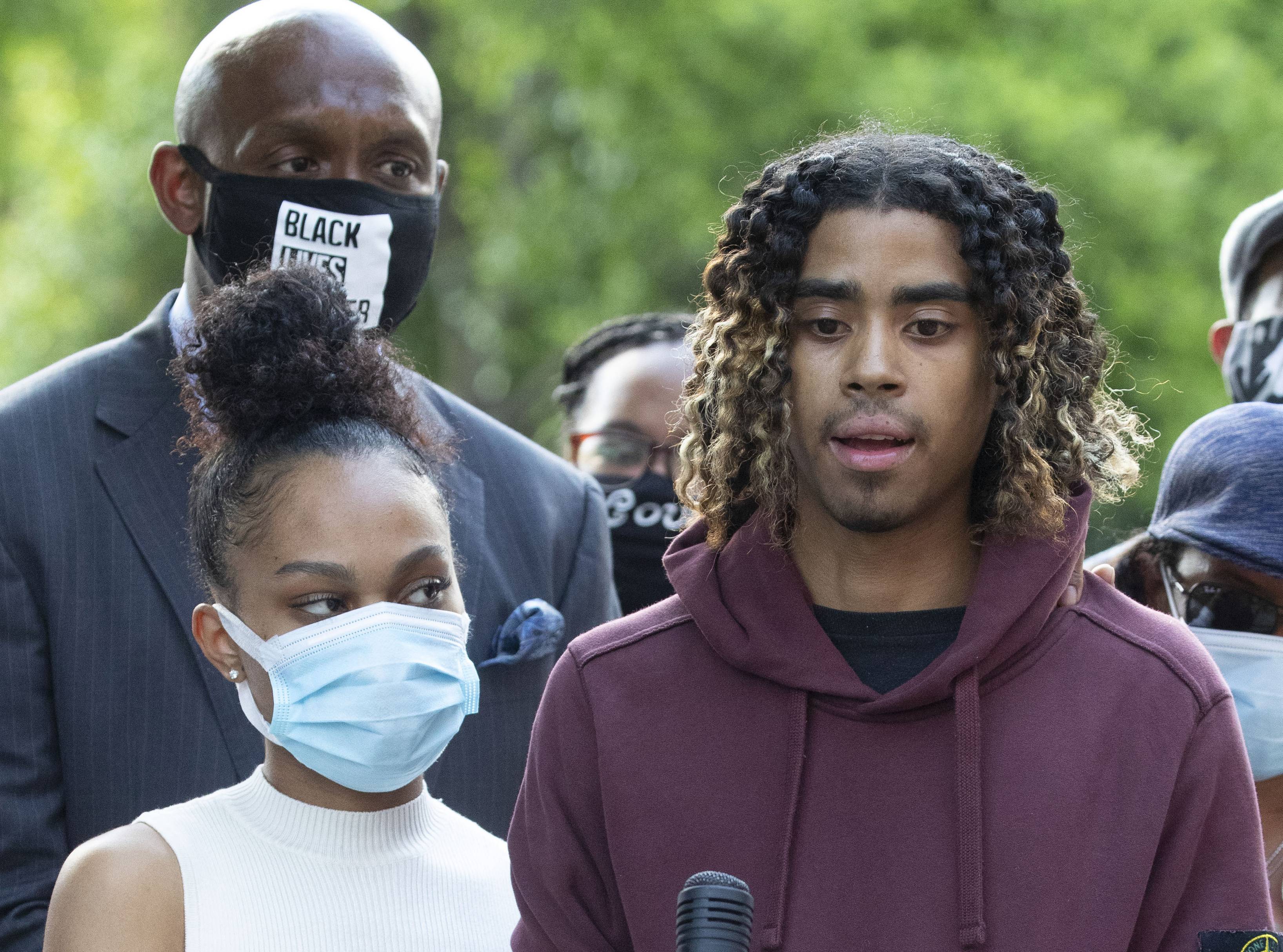 Taniyah Pilgrim holds Messiah Young's bandaged hand as he speaks during a news conference on the campus of Morehouse College Monday, June 1, 2020, in Atlanta. Two Atlanta police officers have been fired and three others placed on desk duty over excessive use of force during a protest arrest incident involving the two college students, Atlanta's mayor said. (AP Photo/John Bazemore)